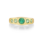 A yellow gold ring featuring five green gemstones set in a curved row.