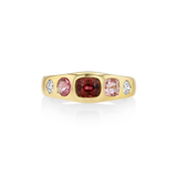 A yellow gold ring featuring a central cushion-cut deep red gemstone flanked by two oval pink gemstones and two small round clear stones, shown on a clean white background.