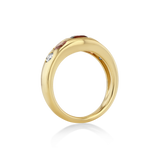 A polished yellow gold ring with small inset gemstones.