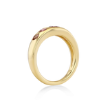 A polished yellow gold ring with a row of small pink gemstones set along the top.