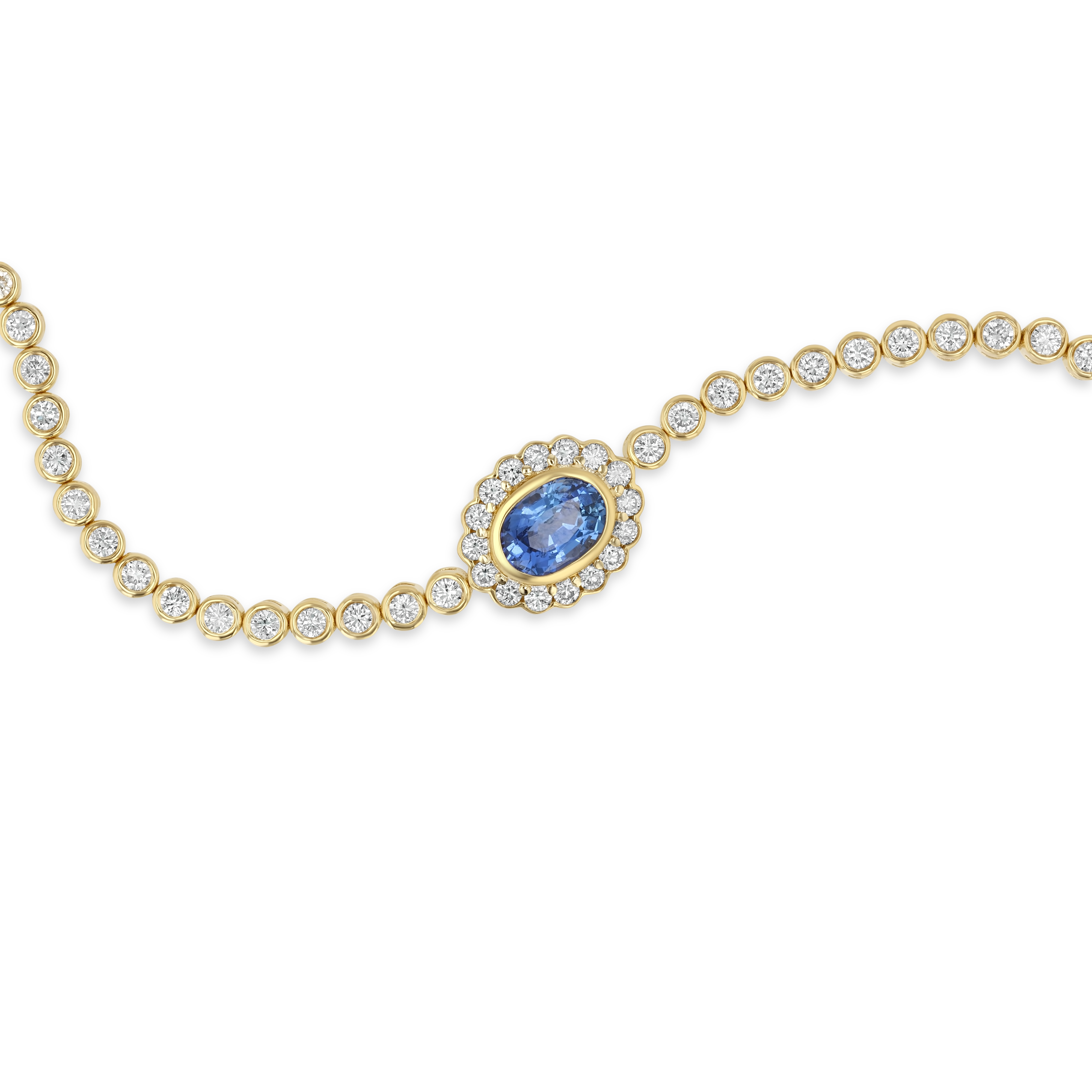 A gold chain bracelet featuring a central oval blue sapphire stone surrounded by a halo of small clear stones, with the rest of the chain lined with round clear stones, shown on a plain white background.