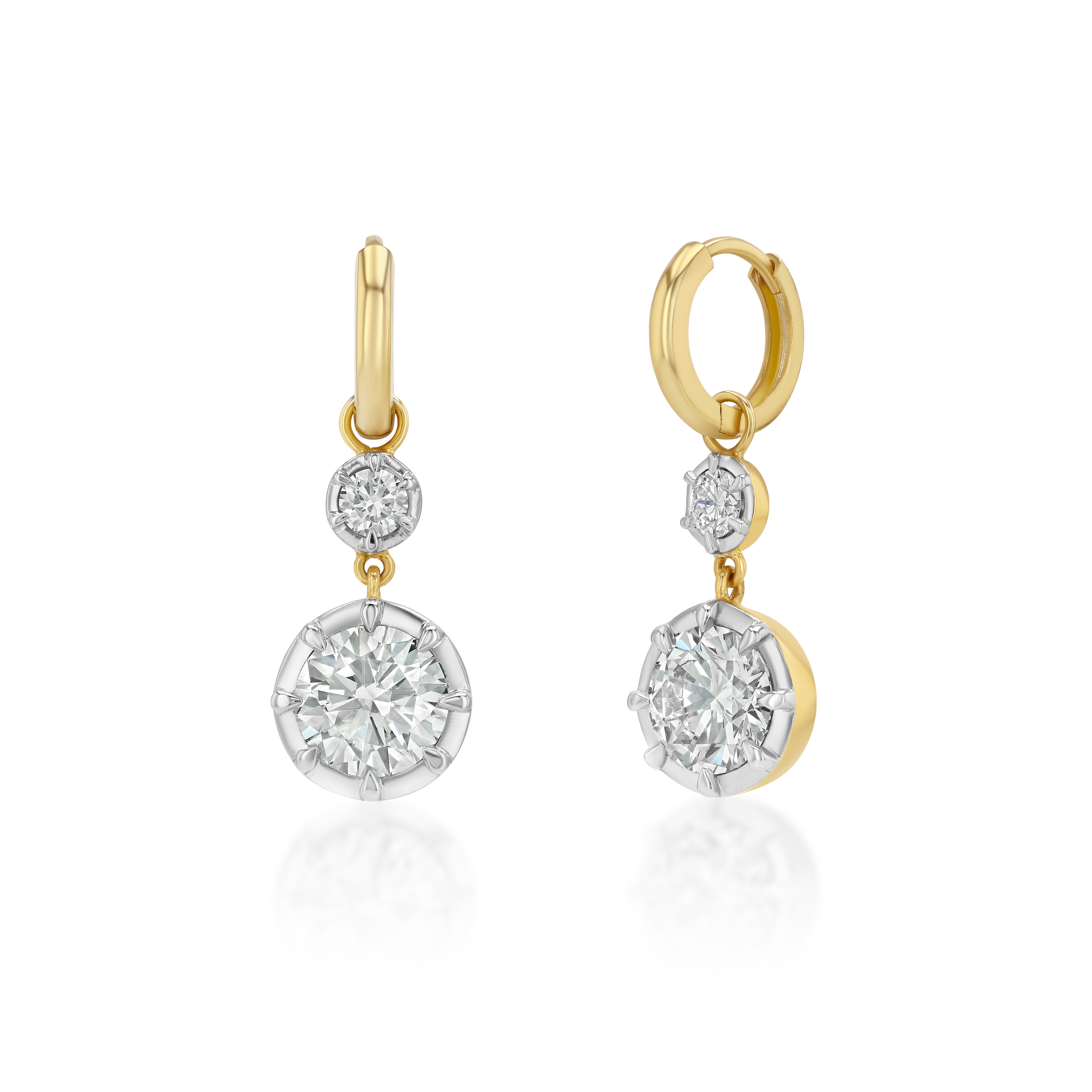 A pair of gold and white gold drop earrings with round-cut diamonds, shown on a clean white background with a soft reflection below.