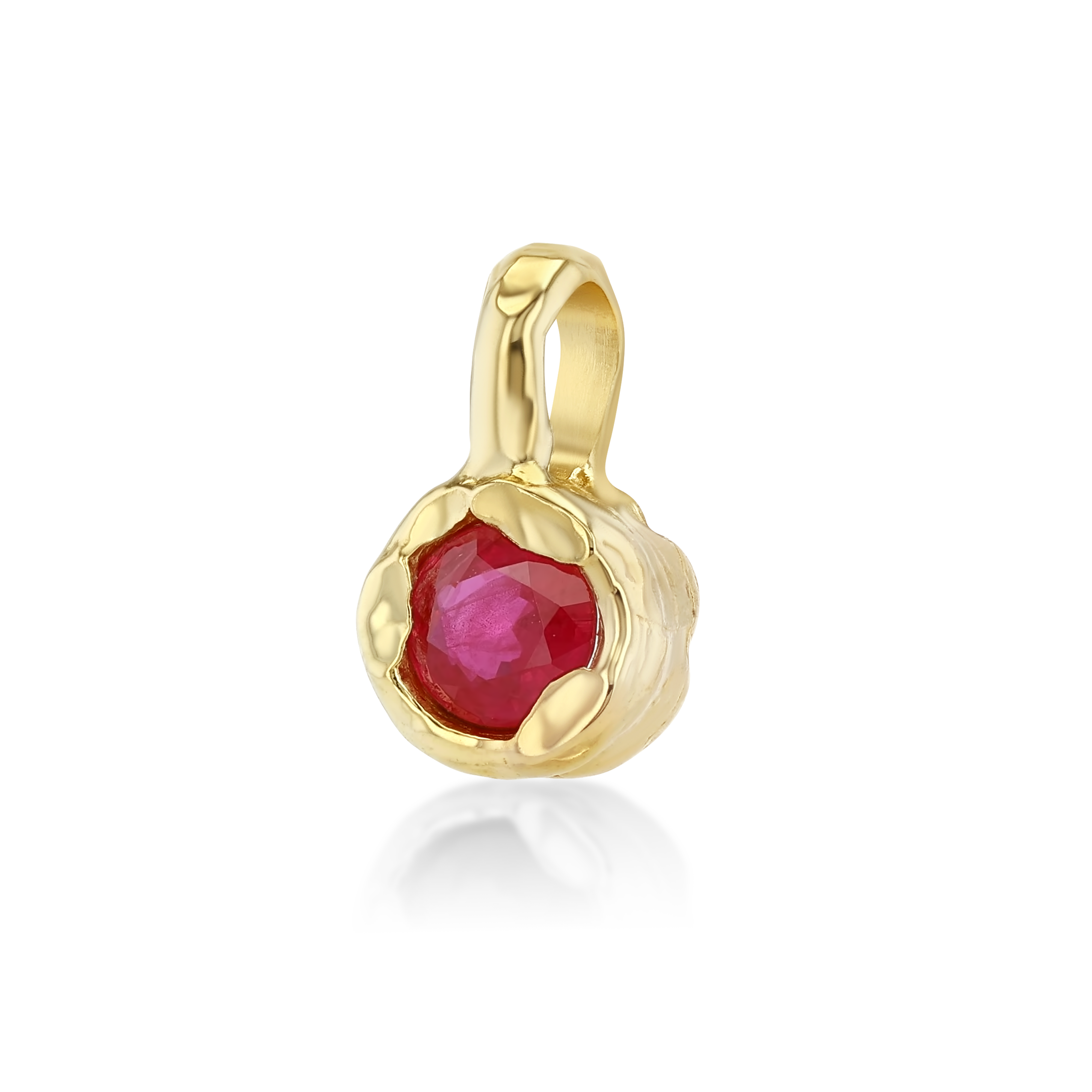 A gold pendant featuring a faceted round red gemstone in a textured, organic-shaped bezel setting, shown on a clean white background with a soft reflection.