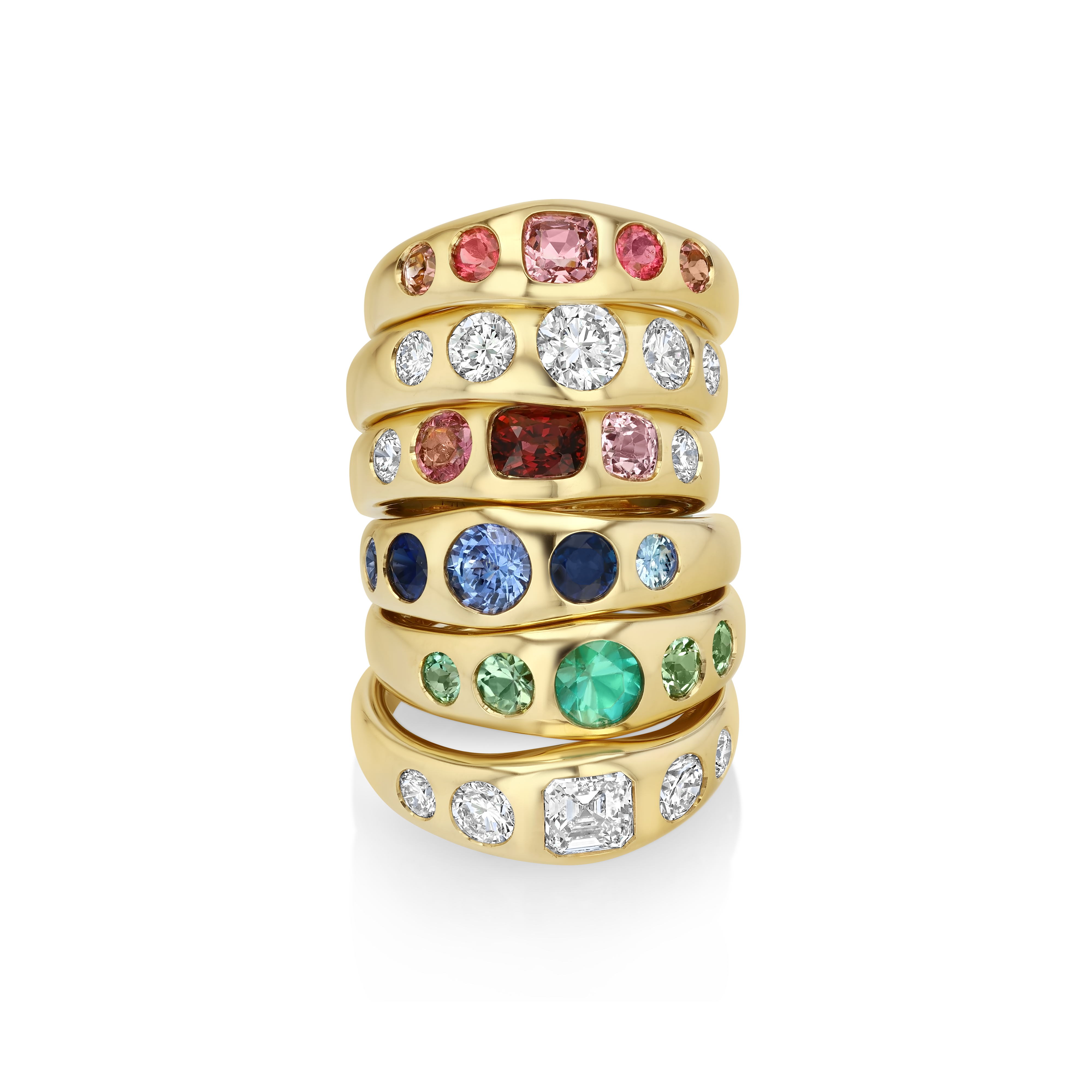 A stack of five gold rings set with multiple colored gemstones, including pink, clear, red, blue, green, and white stones, displayed on a clean white background.